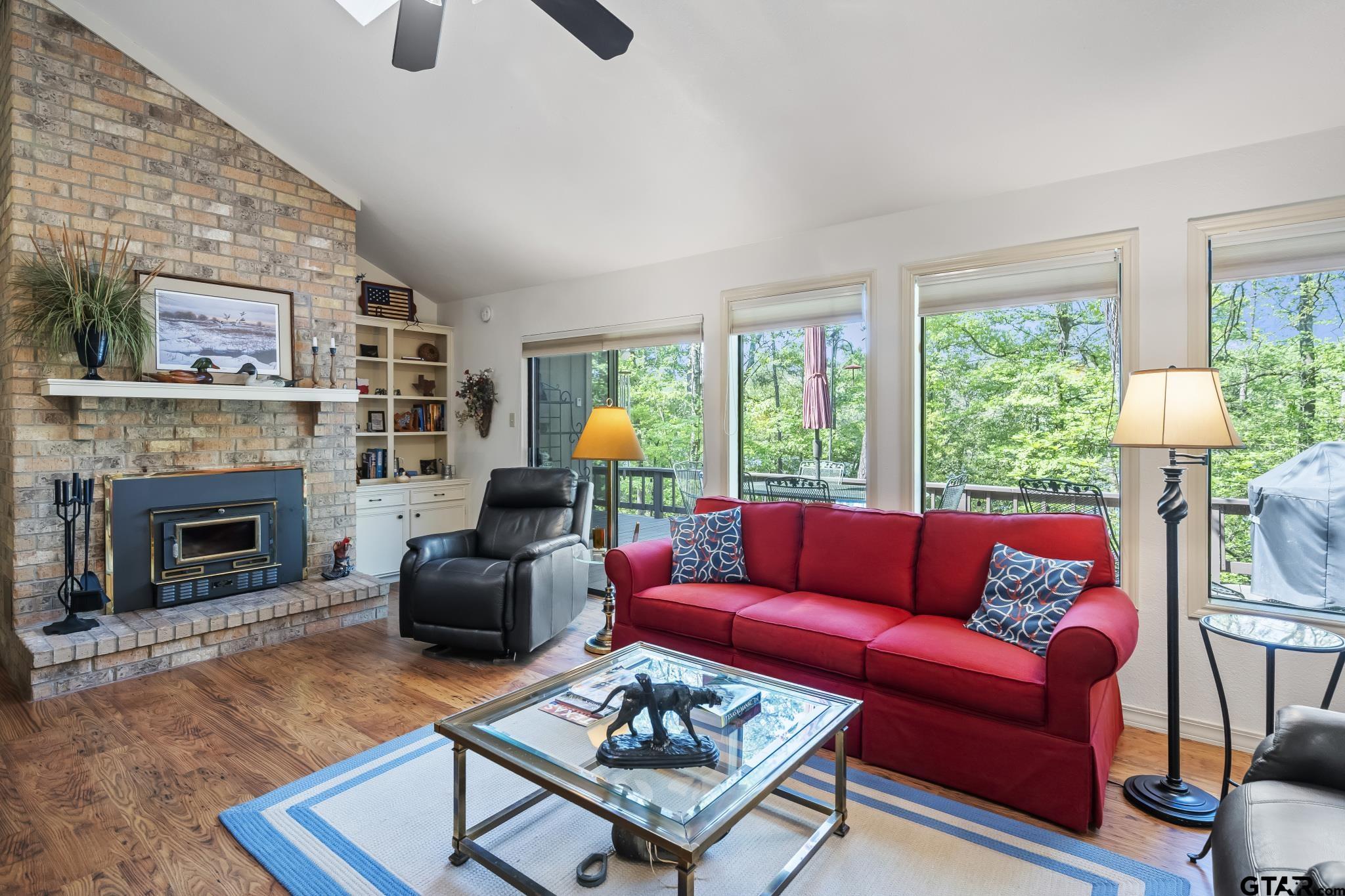 a living room with furniture a fireplace and a large window