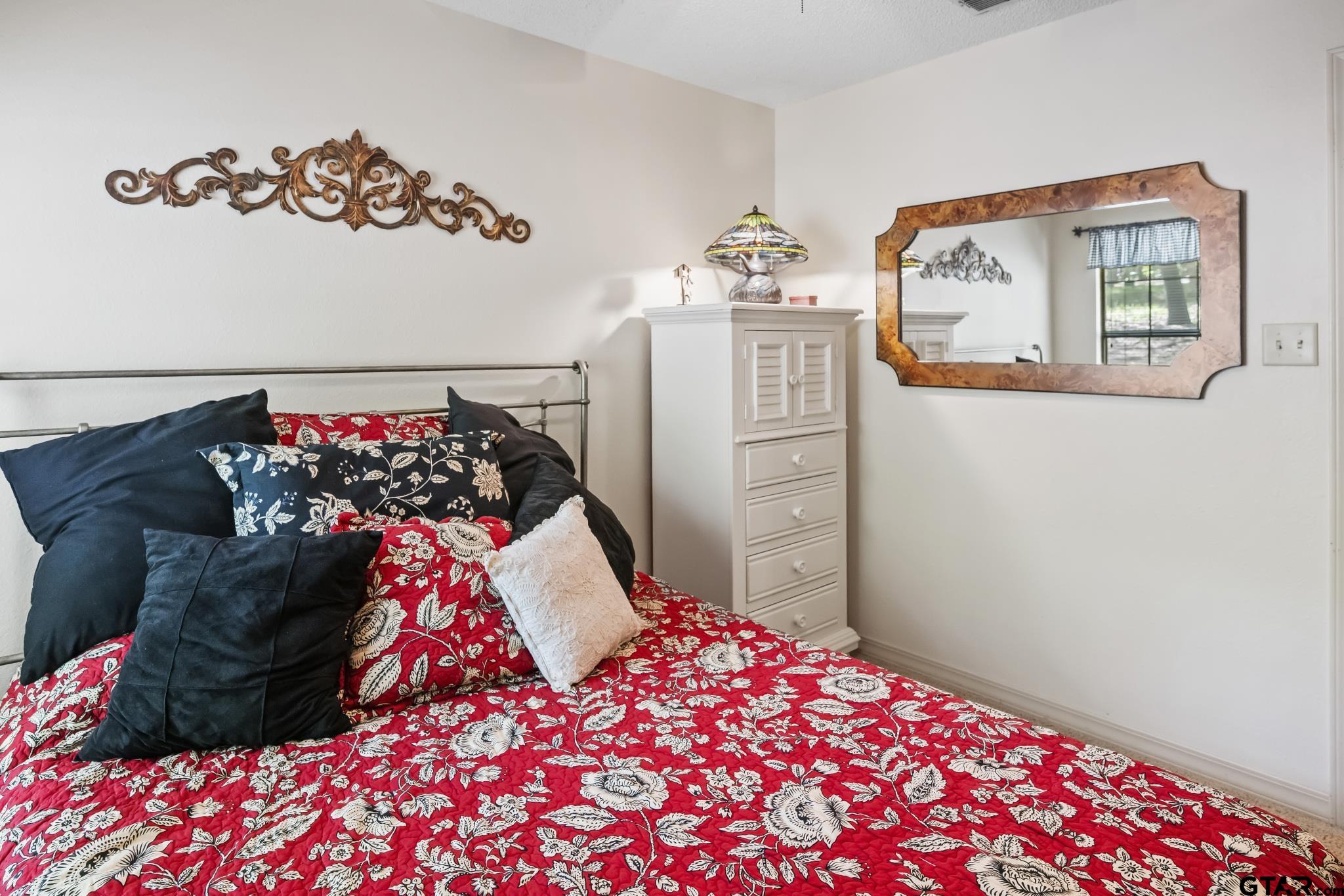 944 Clear Water Trail Holly Lake Ranch, TX 75765 - Photo 18 of 46 a bedroom with a bed and a chandelier