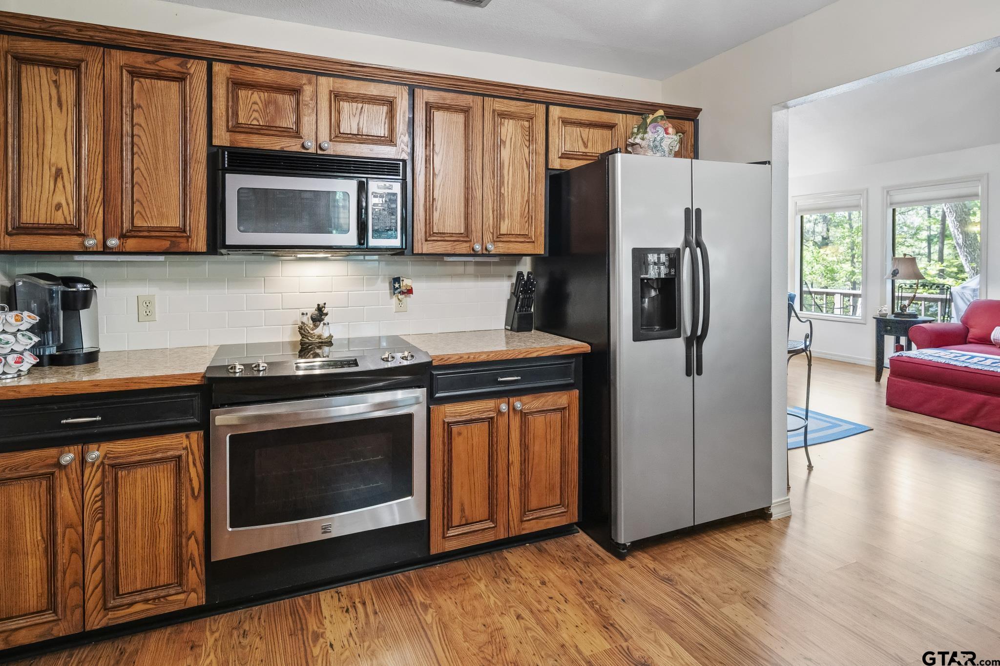 944 Clear Water Trail Holly Lake Ranch, TX 75765 - Photo 9 of 46 a kitchen with stainless steel appliances granite countertop a refrigerator stove and microwave