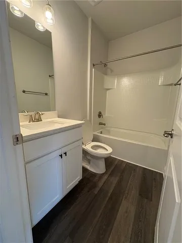 a spacious bathroom with a sink a toilet a mirror and shower