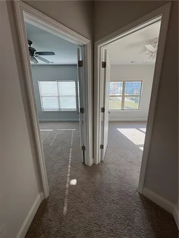 en empty room with windows and ceiling fan