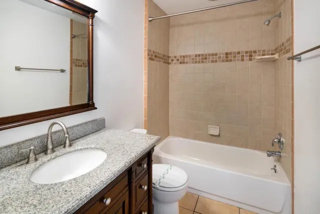 a bathroom with a granite countertop sink mirror toilet and bathtub