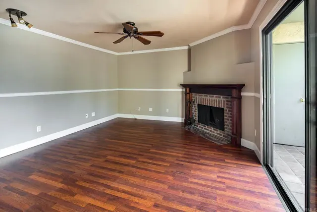a view of empty room with wooden floor and fireplace