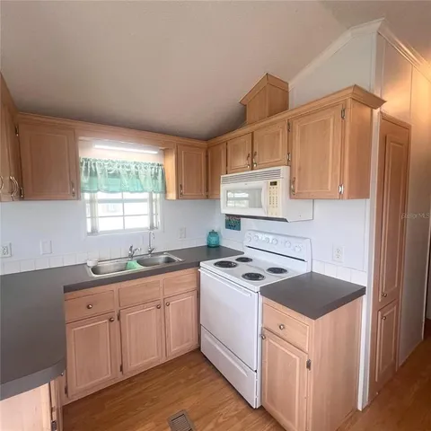 a kitchen with granite countertop a sink stove and cabinets
