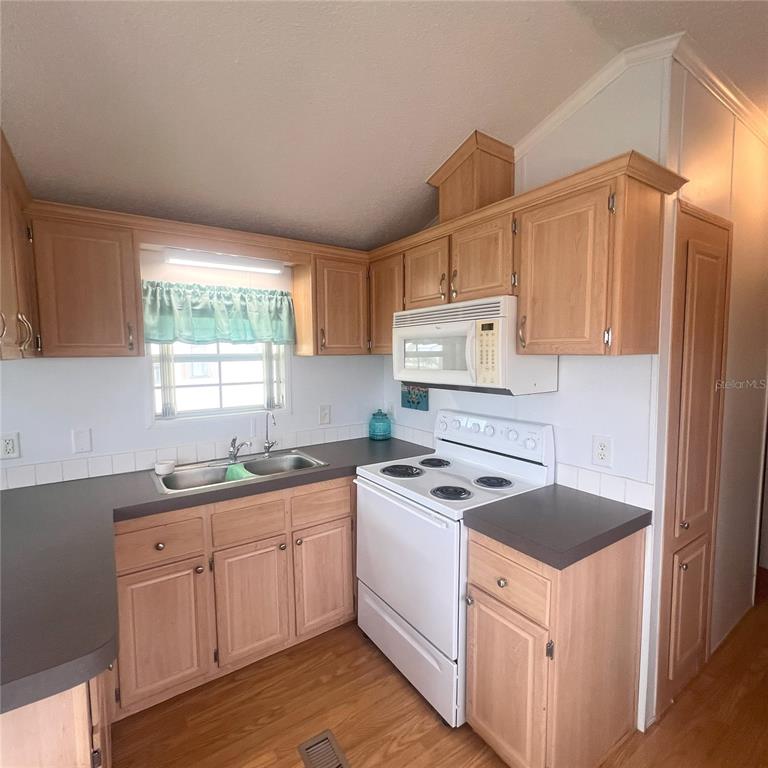 1202 Snook Punta Gorda, FL 33950 - Photo 8 of 34 a kitchen with granite countertop a sink stove and cabinets