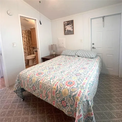 a bedroom with a bed and a mirror