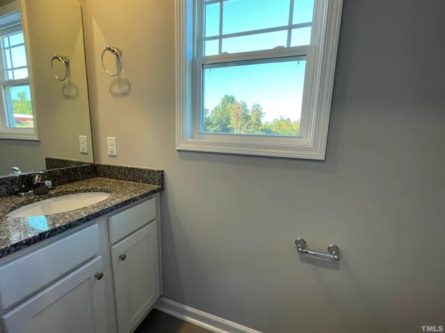 a bathroom with a granite countertop sink a vanity and a mirror