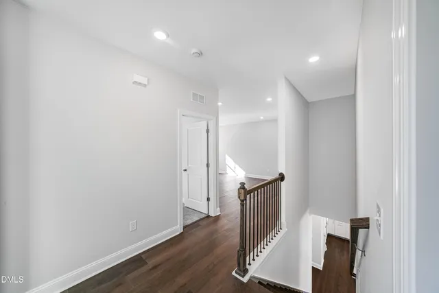 a kitchen with stainless steel appliances granite countertop a stove a refrigerator white cabinets and wooden floor