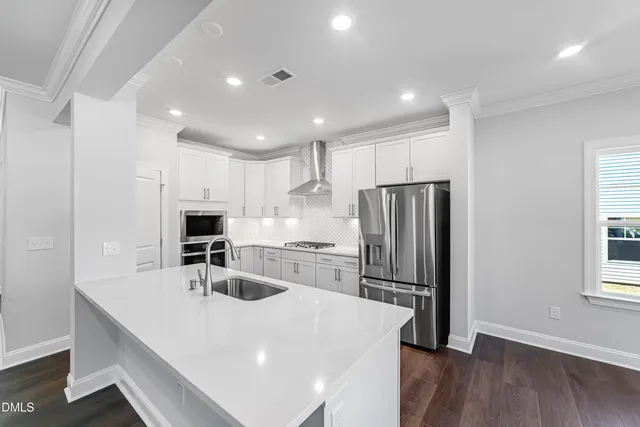 a kitchen with kitchen island a sink stainless steel appliances and cabinets