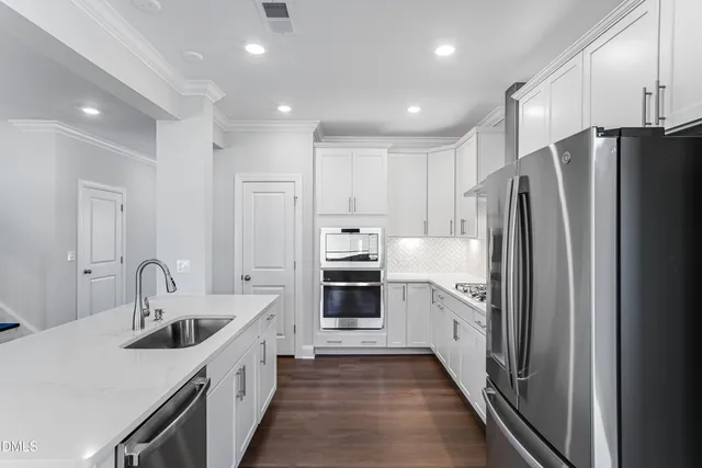 a kitchen with white cabinets and stainless steel appliances
