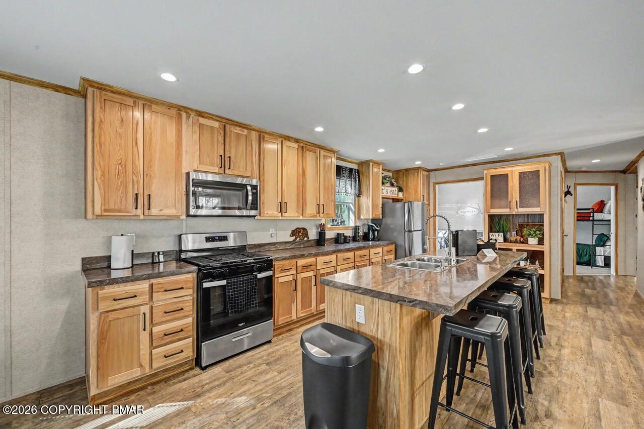 2194 Snow Hill Falls Road Cresco, PA 18326 - Photo 30 of 63 a kitchen with stainless steel appliances granite countertop a stove top oven a sink dishwasher a dining table and chairs with wooden floor