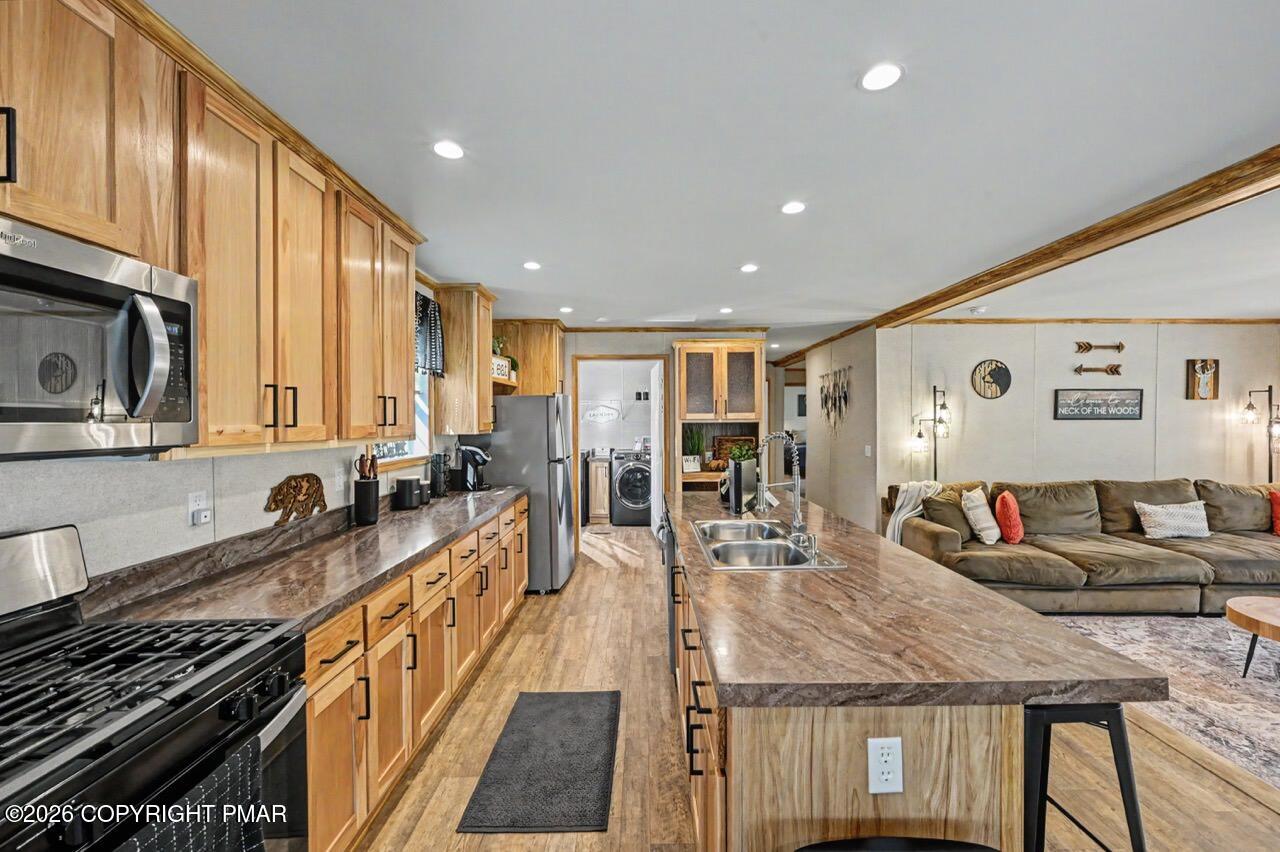 2194 Snow Hill Falls Road Cresco, PA 18326 - Photo 31 of 63 a kitchen with stainless steel appliances granite countertop a stove top oven a sink dishwasher a dining table and chairs with wooden floor