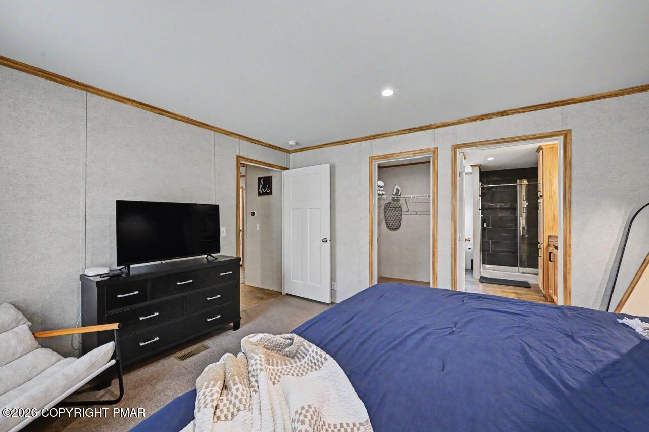 2194 Snow Hill Falls Road Cresco, PA 18326 - Photo 40 of 63 a bedroom with a bed and a flat screen tv