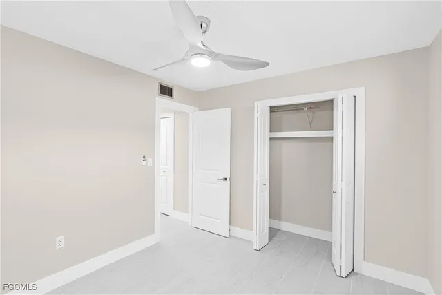 an empty room with fan and entrance