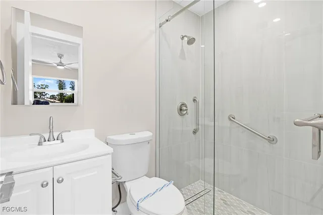a bathroom with a toilet sink vanity and shower