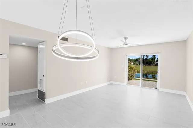 an empty room with a windows and fan