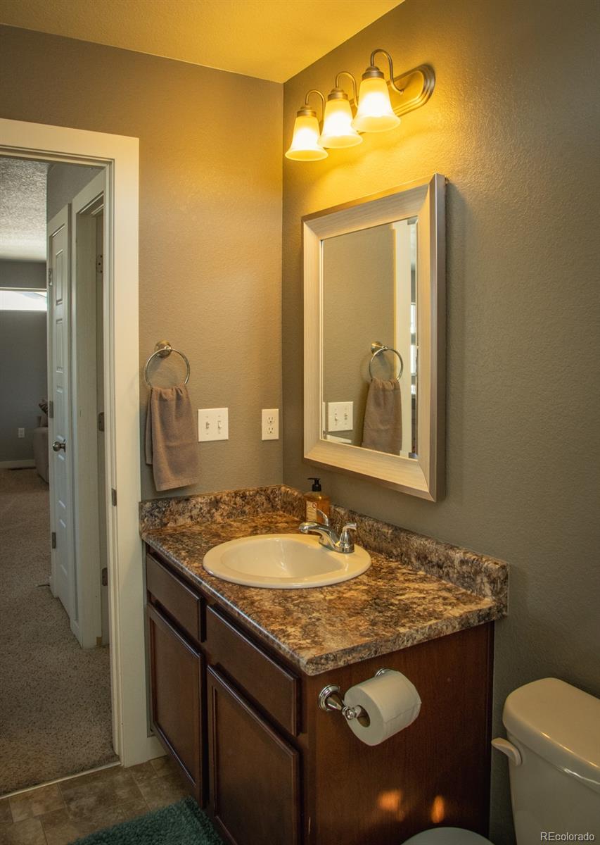 4428 Vindaloo Drive Castle Rock, CO 80109 - Photo 22 of 35 a bathroom with a granite countertop sink and a mirror