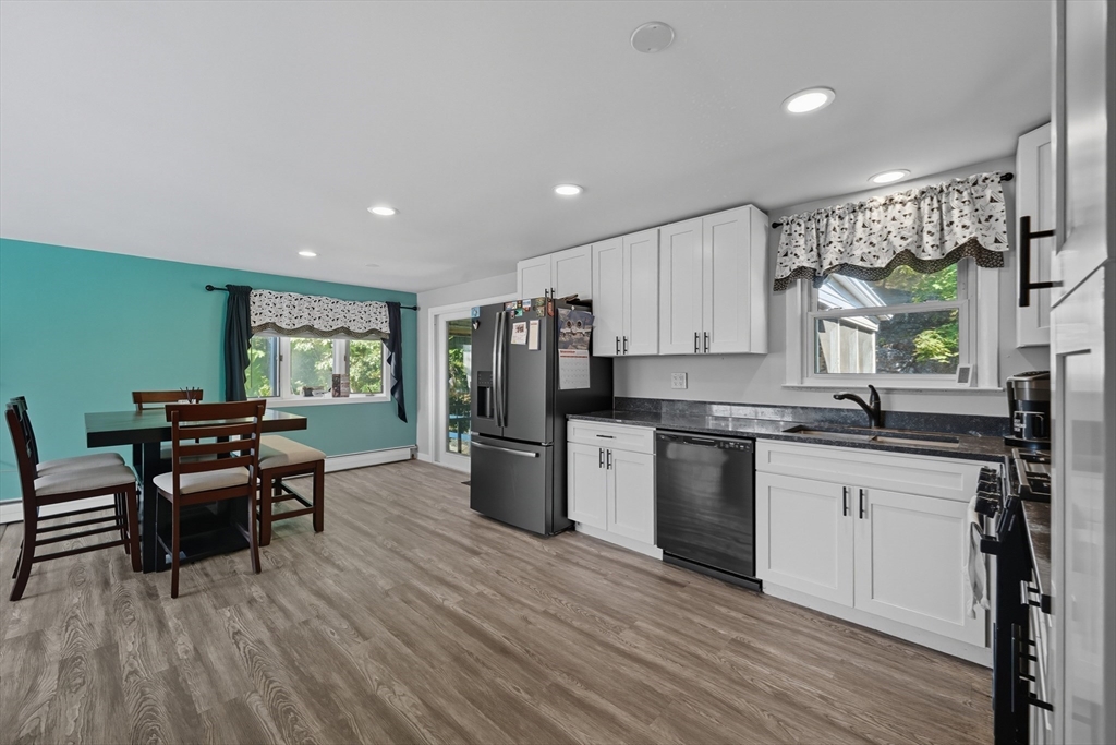 35 Oak Ridge Circle Lynn, MA 01904 - Photo 13 of 37 a kitchen with stainless steel appliances granite countertop wooden floors a stove and white cabinets