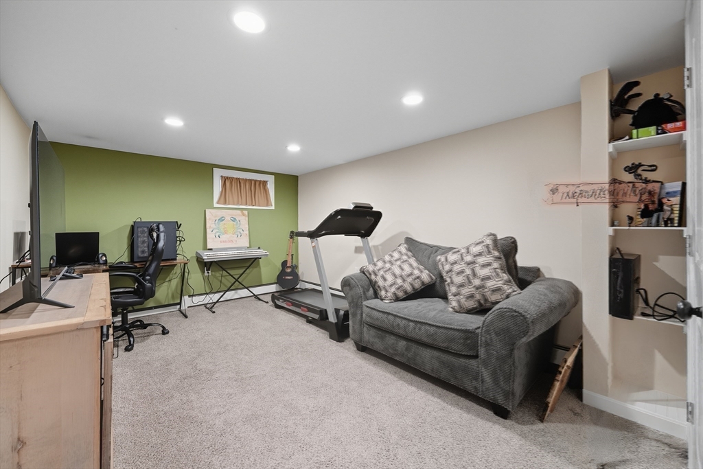 35 Oak Ridge Circle Lynn, MA 01904 - Photo 27 of 37 a living room with furniture gym equipment and a flat screen tv