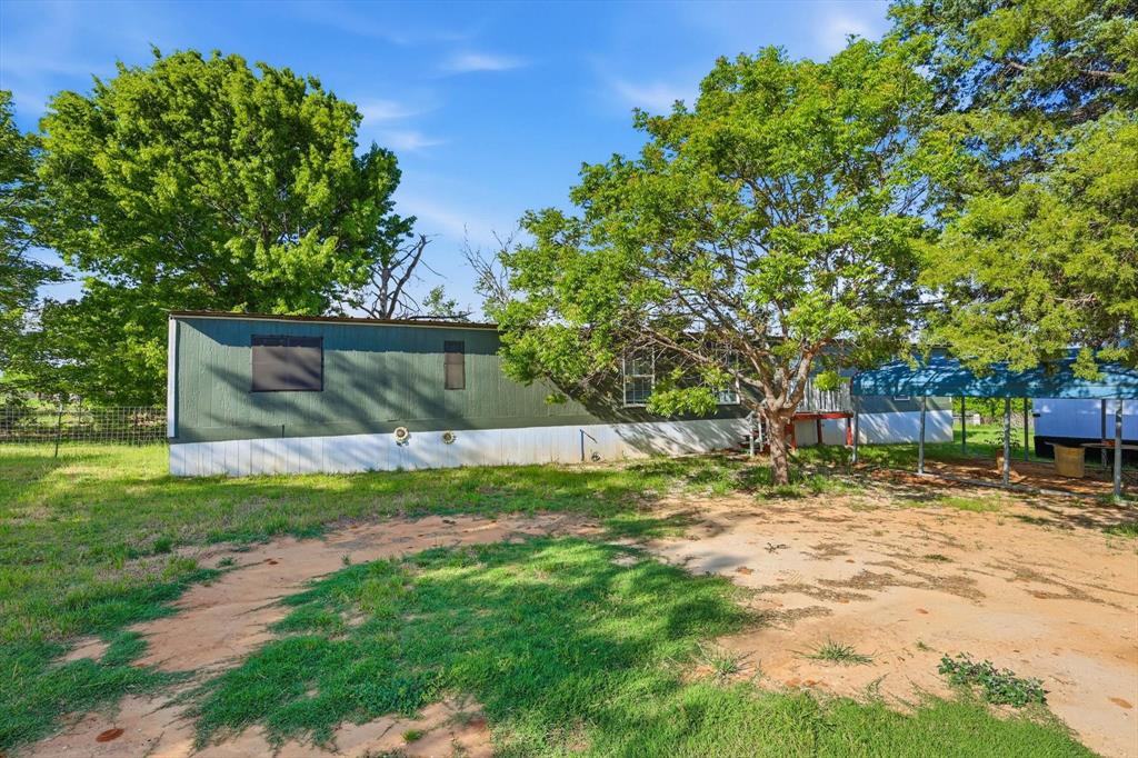 316 Summit Drive Springtown, TX 76082 - Photo 2 of 39 The property features a green exterior with white trim, set amidst mature trees