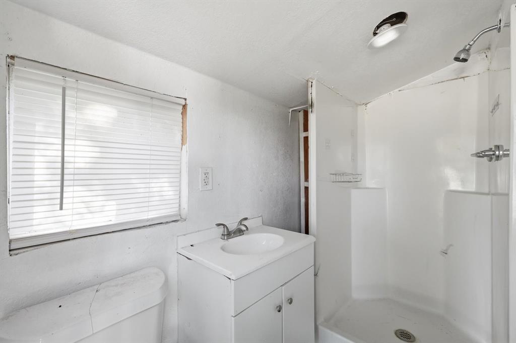 316 Summit Drive Springtown, TX 76082 - Photo 25 of 39 Bathroom with a white vanity, an integrated sink, a shower stall, and a window with blinds
