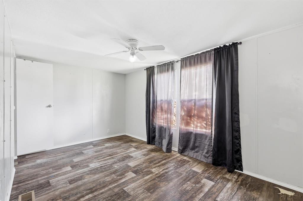 316 Summit Drive Springtown, TX 76082 - Photo 26 of 39 This room features wood-look flooring, a ceiling fan, and large windows with privacy curtains