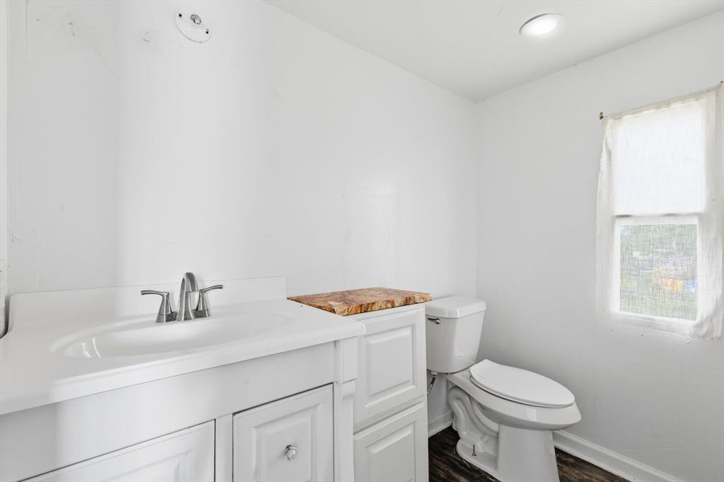 316 Summit Drive Springtown, TX 76082 - Photo 29 of 39 Bathroom featuring a white vanity with a built-in sink and brushed nickel faucet, a toilet, and a window providing natural light