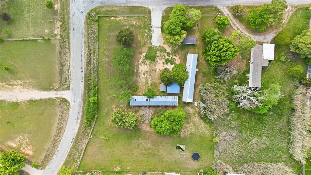 316 Summit Drive Springtown, TX 76082 - Photo 35 of 39 Aerial view of the property featuring extensive green areas, mature trees, and a paved road bordering the perimeter