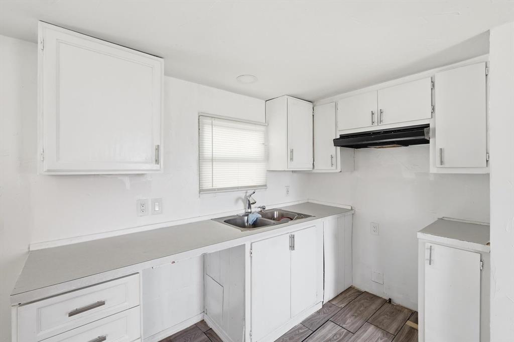 316 Summit Drive Springtown, TX 76082 - Photo 7 of 39 The kitchen features white cabinetry, a double basin sink, and a window with blinds