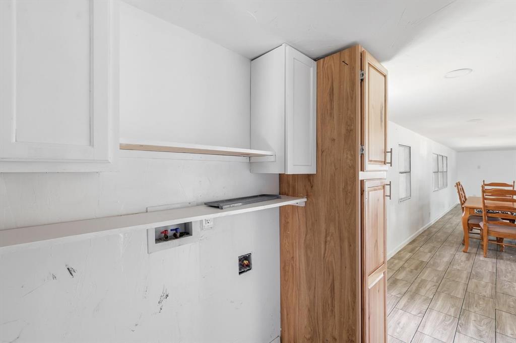 316 Summit Drive Springtown, TX 76082 - Photo 9 of 39 Utility area featuring white upper cabinetry, a long shelf, and plumbing hookups