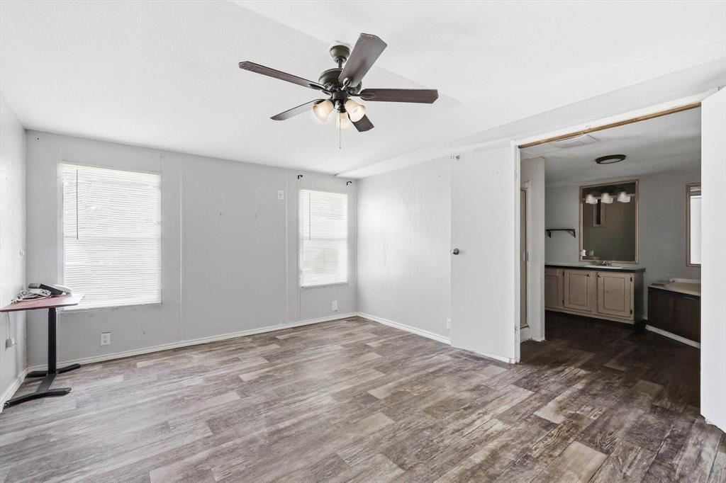 316 Summit Drive Springtown, TX 76082 - Photo 10 of 39 Spacious room featuring wood-look flooring, multiple windows providing natural light, and a ceiling fan