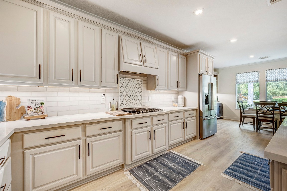 2600 Silverstone Way Conroe, TX 77304 - Photo 15 of 49 a kitchen with granite countertop white cabinets and white appliances