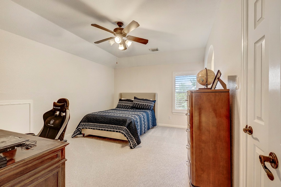 2600 Silverstone Way Conroe, TX 77304 - Photo 32 of 49 a bedroom with a bed and a ceiling fan