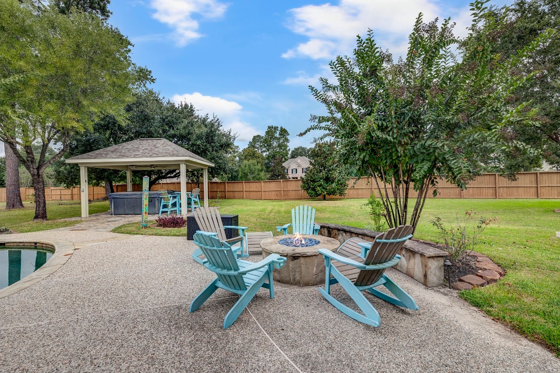 2600 Silverstone Way Conroe, TX 77304 - Photo 39 of 49 a view of a patio with a table chairs and a fire pit