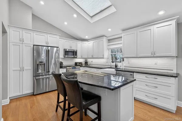 a kitchen with kitchen island granite countertop a center island cabinets and stainless steel appliances