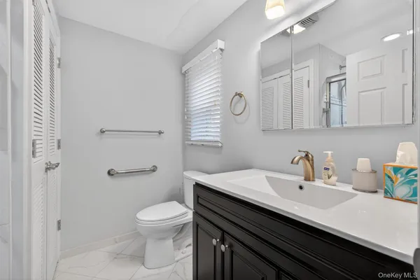 a bathroom with a sink a toilet and a mirror