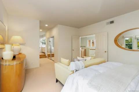 a bedroom with a large bed and a painting on the wall