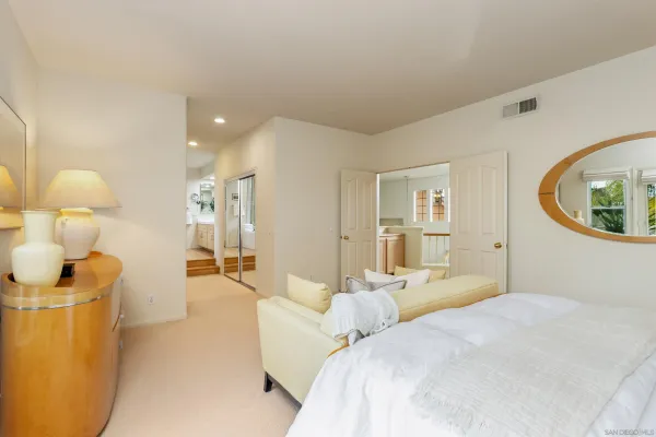 a bedroom with a large bed and a painting on the wall