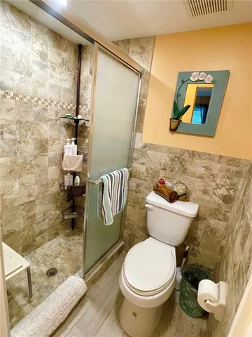a bathroom with a toilet and a shower