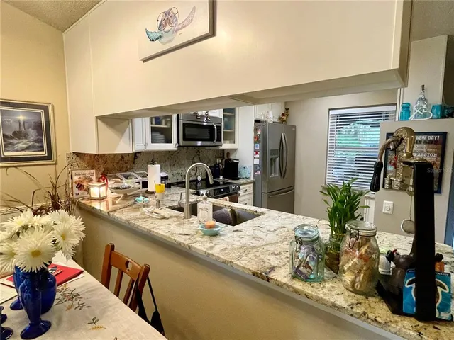 a kitchen with sink refrigerator and microwave