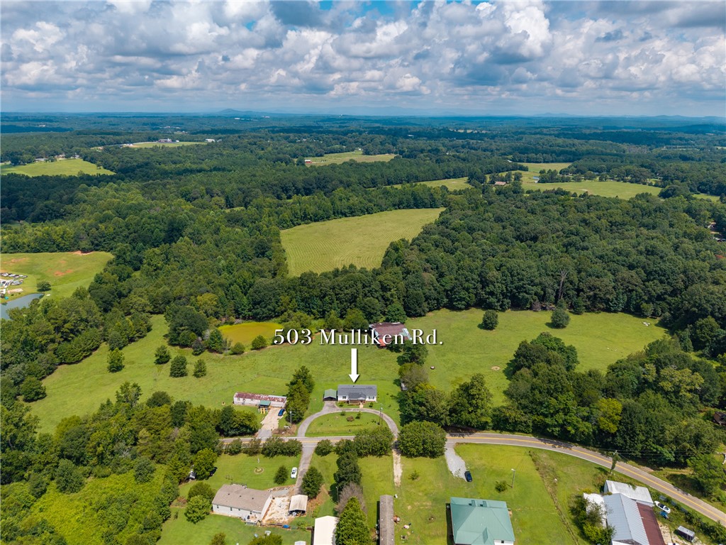 503 Mulliken Road Central, SC 29630 - Photo 35 of 50 An aerial perspective reveals a private residence nestled amidst a panorama of rolling green fields and dense woodland.