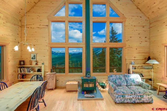 a living room with furniture floor to ceiling window and wooden floor