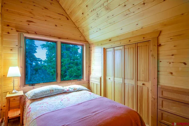 a bedroom with a bed and large window