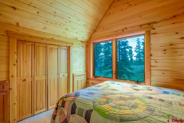 a bed sitting in a bedroom next to a window