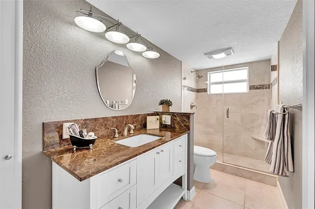 a view of a house with a small yard and large trees