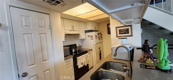 a view of a storage and utility room with multiple dryer and washer