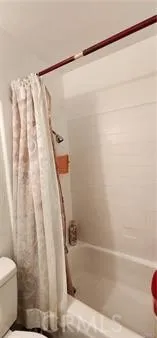 a bathroom with a shower curtain and a toilet