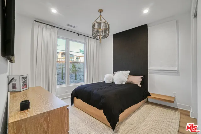 a living room with furniture floor to ceiling window and a flat screen tv