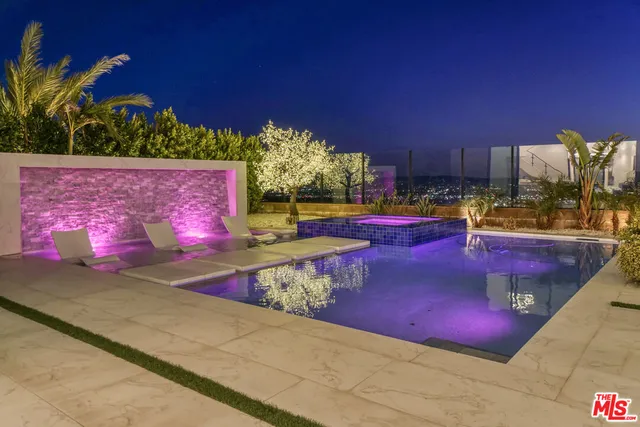 a view of a tennis ground with a table and chairs