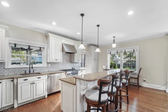 a kitchen with a dining table chairs sink and cabinets